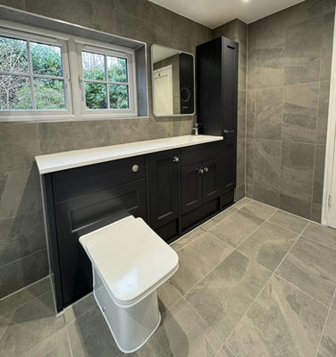 Renovated bathroom with a walk-in shower, low tray and navy furniture