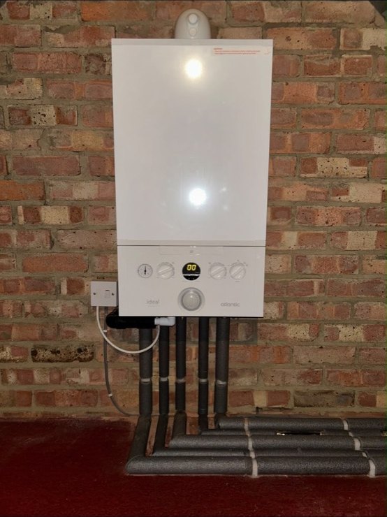 Ideal Atlantic boiler installed on an exposed brick wall with neatly insulated pipework