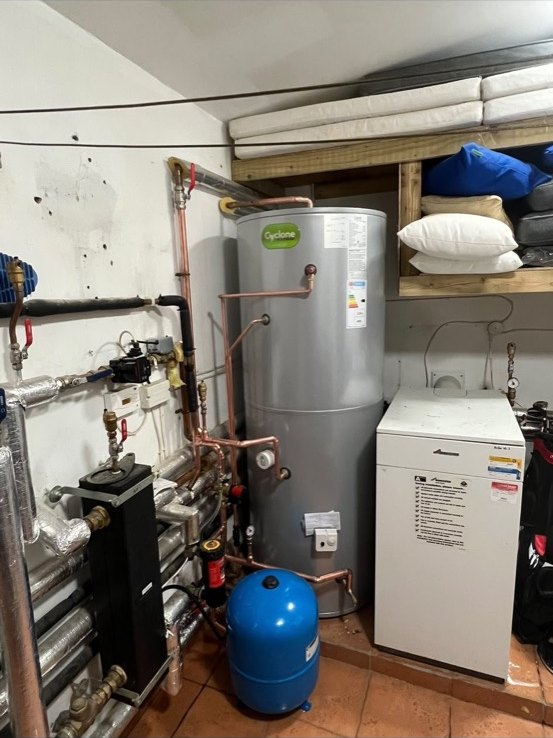 Unvented Joule Cyclone hot water cylinder beside a Worcester floor-standing boiler, with copper pipework and a blue expansion vessel