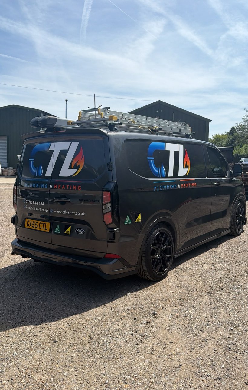 The black wrapped CTL Plumbing & Heating Ford Transit Custom van with roof ladders, parked at the yard